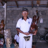 Men make traditional wooden statues in Bali.