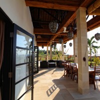 The covered terrace of the villa in Bali overlooking the sea.