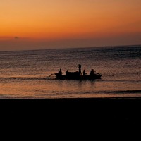 A fishing boat on the Bali sea at the setting of the sun.