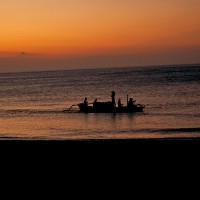 A fishing boat on the Bali sea at the setting of the sun.